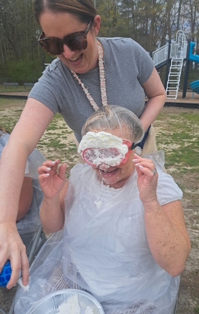 teacher with whipped cream on her face from being pied 
