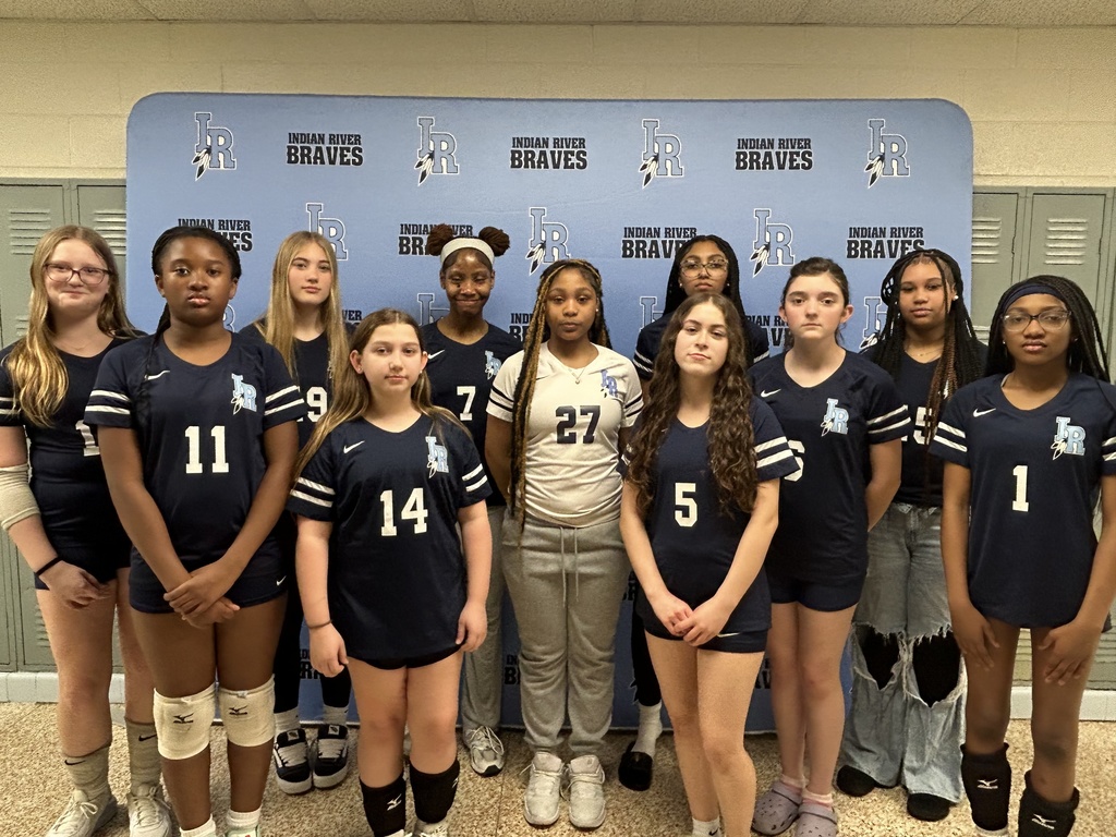 middle school volleyball players posing for a group photo