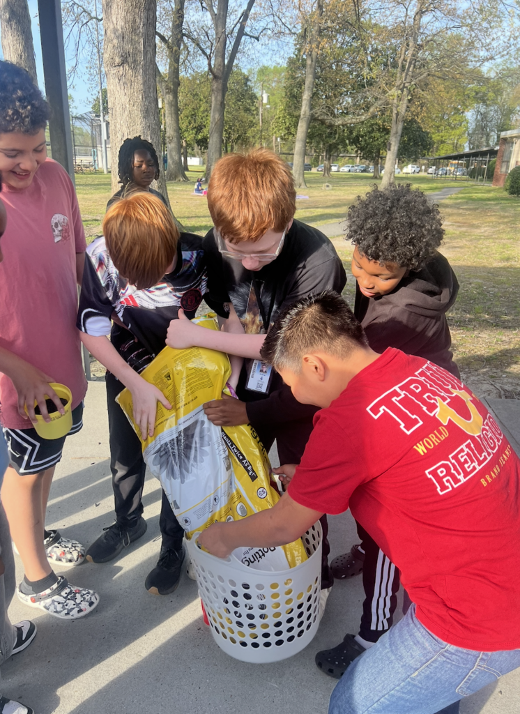 students working together to plant potatoes