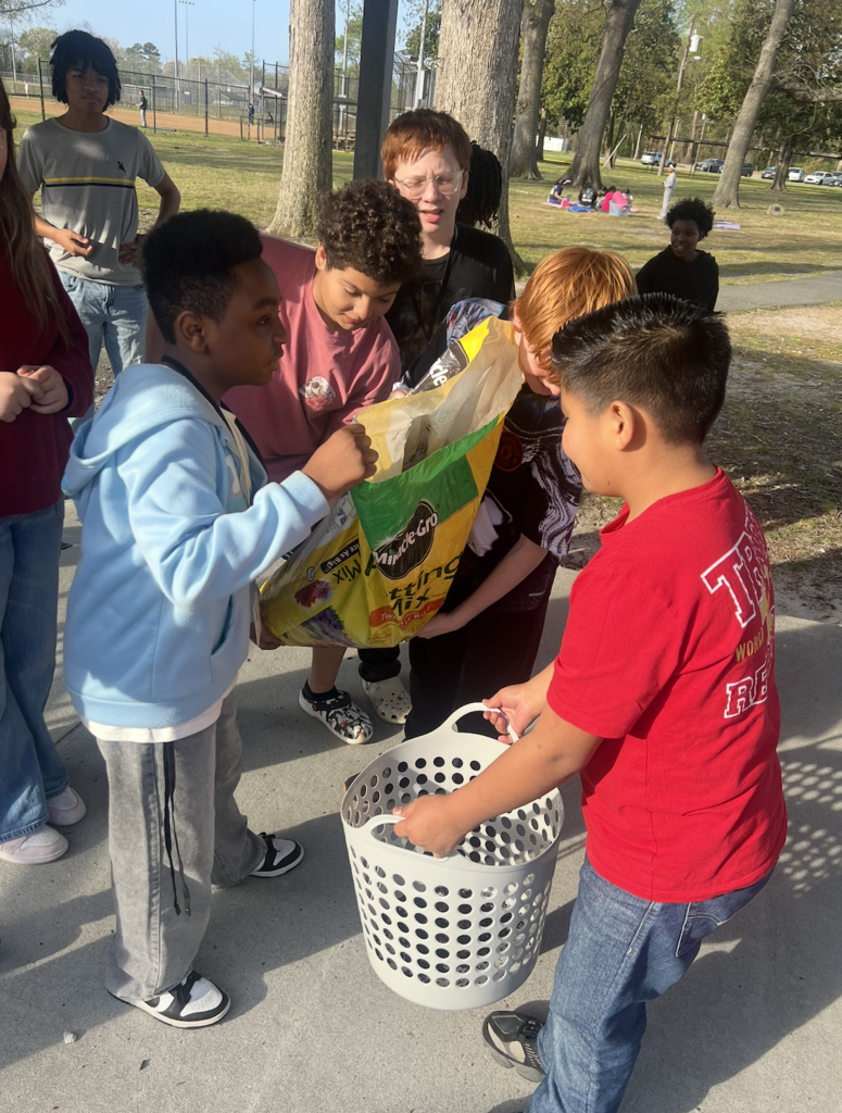students working together to plant potatoes