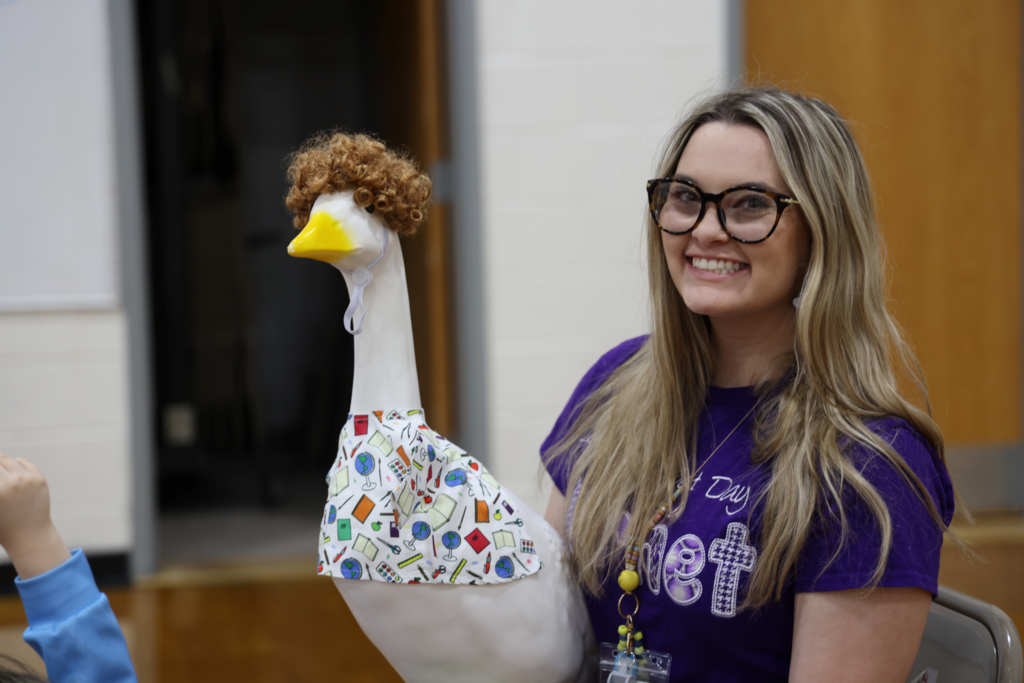 teacher proudly shows off her class goose during presentation