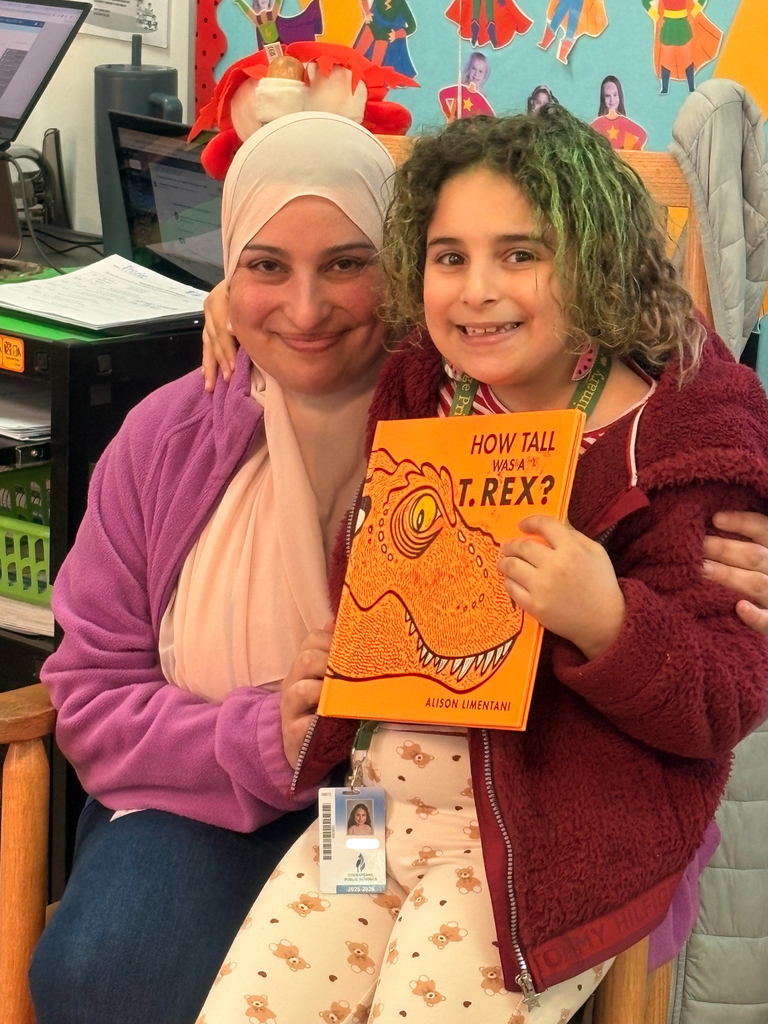 A proud student poses with their parent following their visit as a guest reader in 2nd grade.