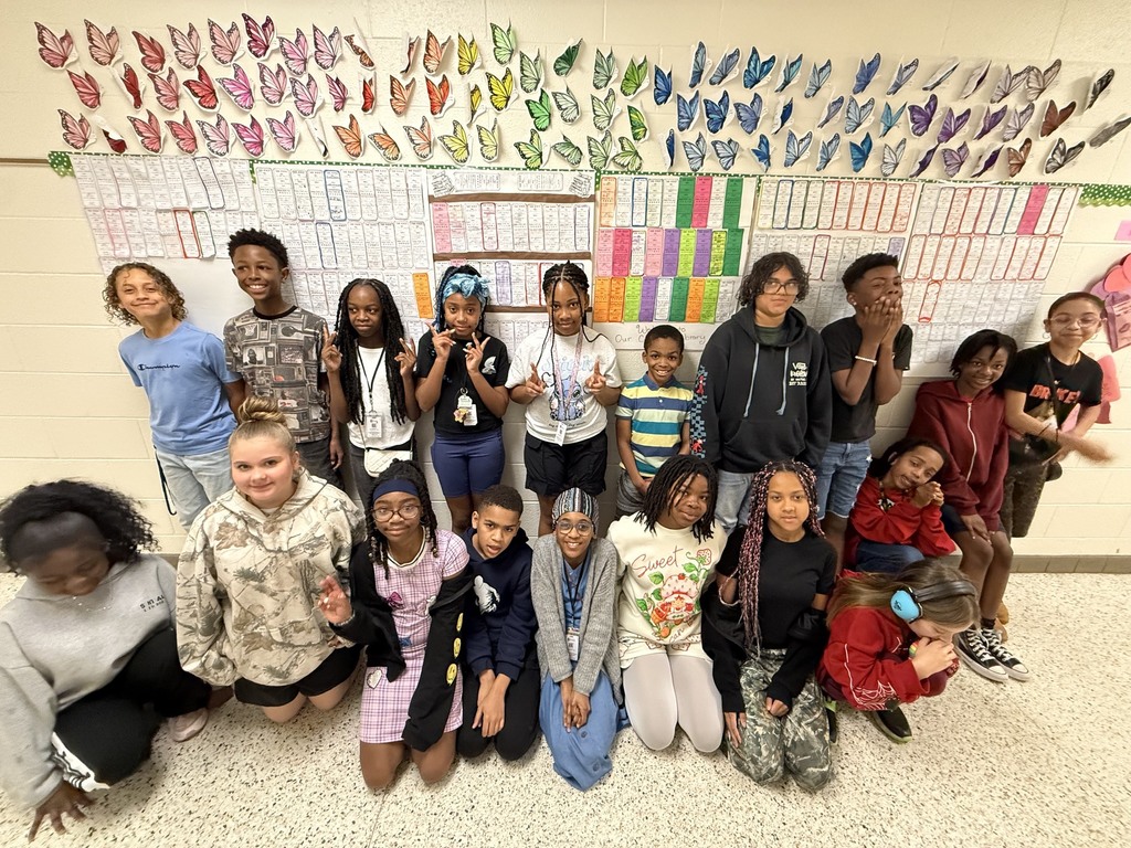 Caswell's Class in the hallway in front of the Book Spine display of the books they read.