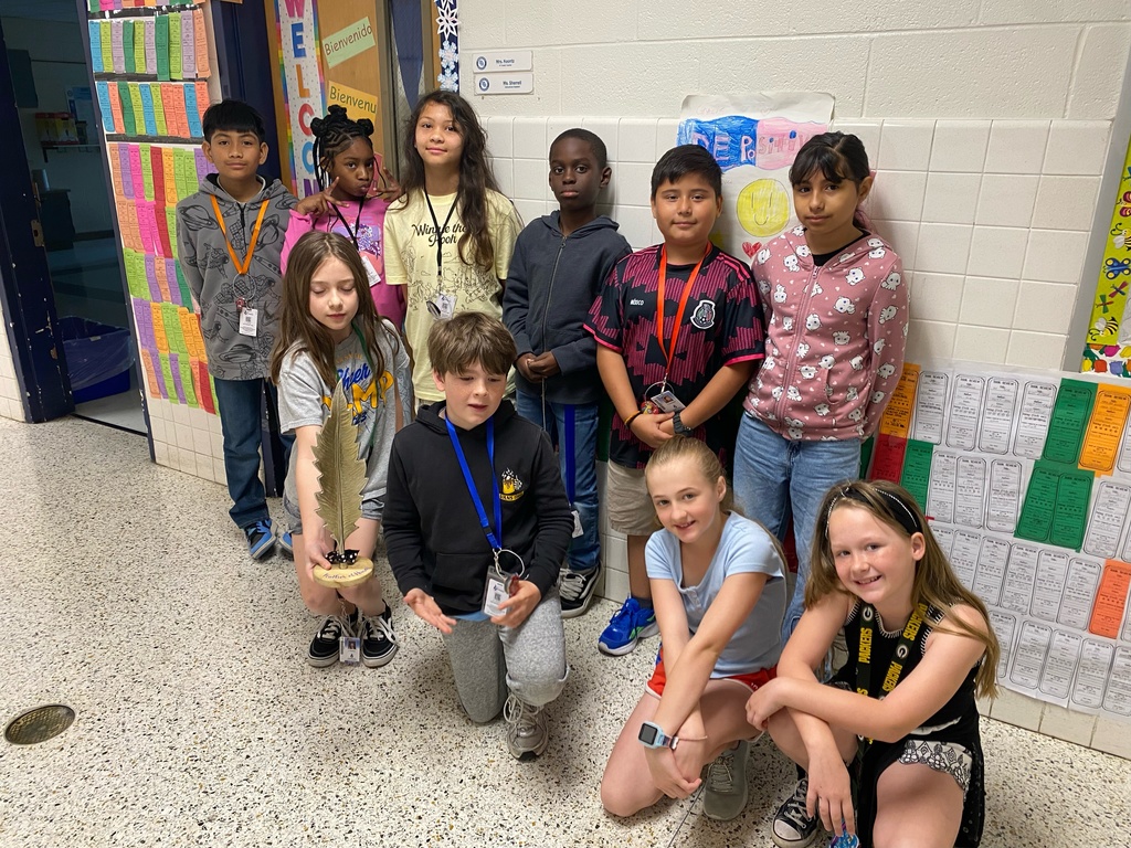 Students proudly showing off the Golden Feather outside their classroom.