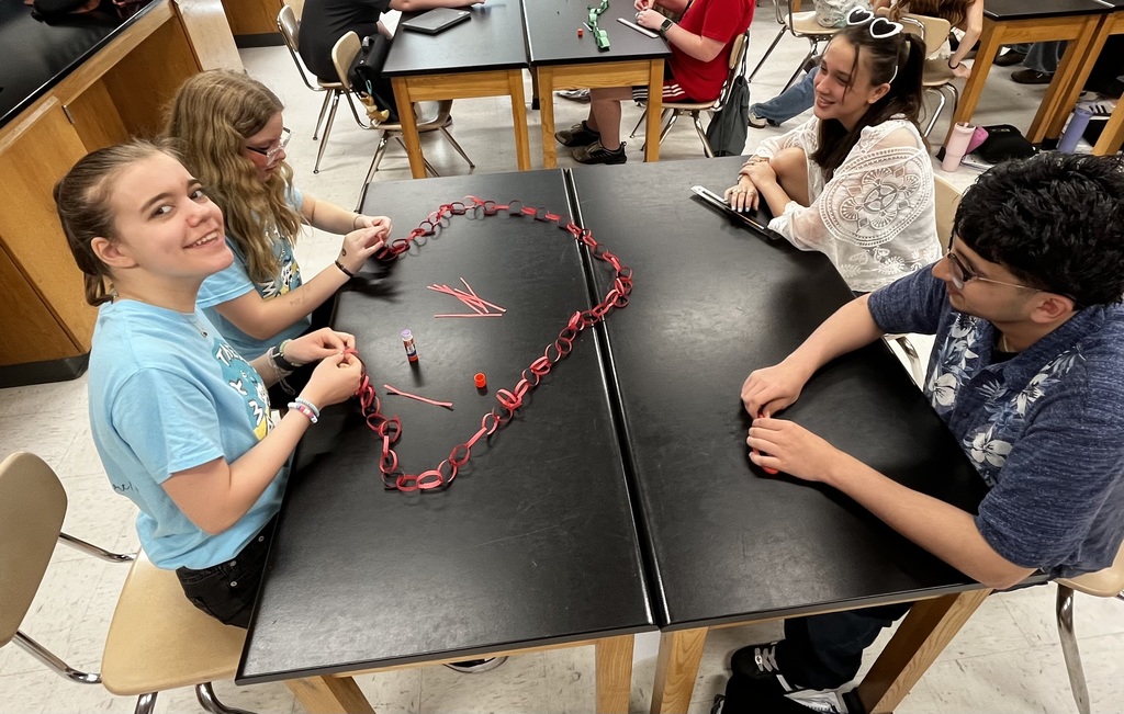 students working in a small group to create a paper chain