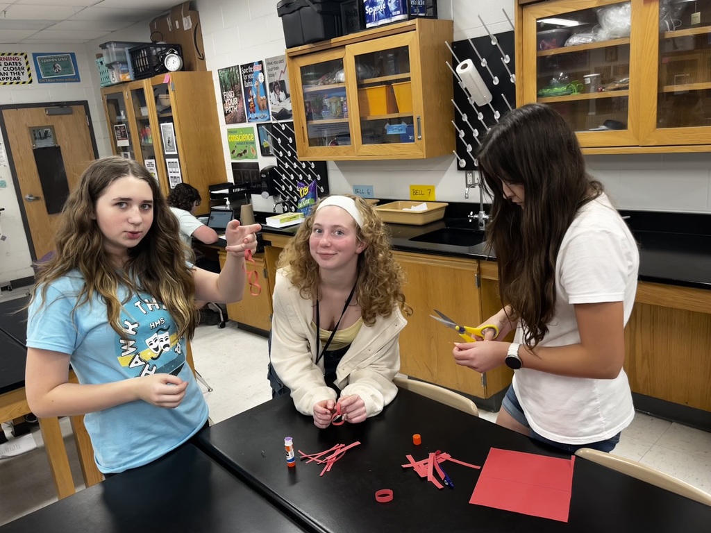 students working in a small group to create a paper chain