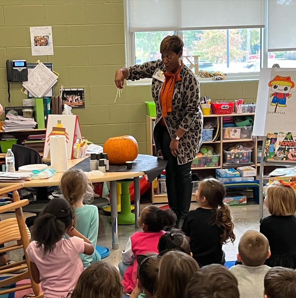 Ms. Baker-Hardison excitedly pulling the seeds out of a pumpkin in a kindergarten classroom