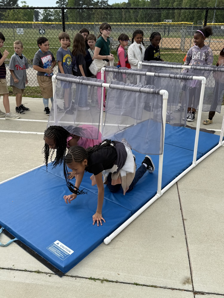 kids practicing staying down while they crawl out of a house for fire safety.