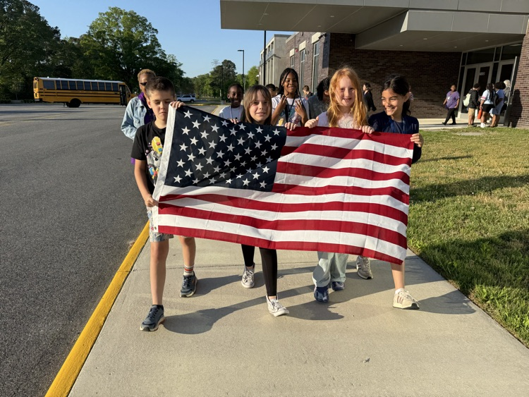 Kids gathered for the month of the Military Kid Parade. Students smiled while holding an American Flag.