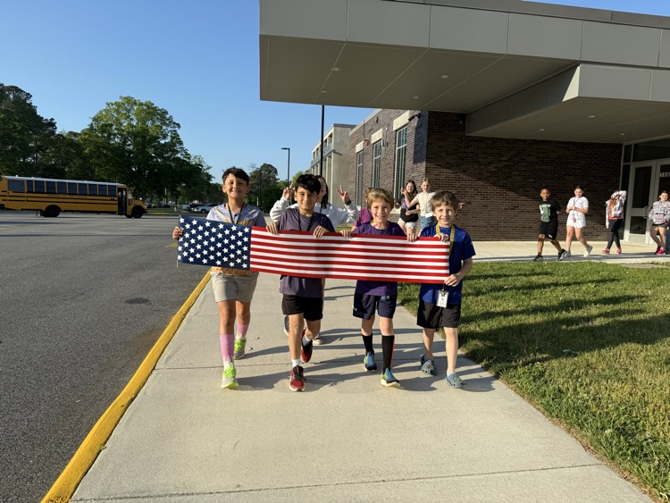 Kids gathered for the month of the Military Kid Parade. Students smiled while holding an American Flag.