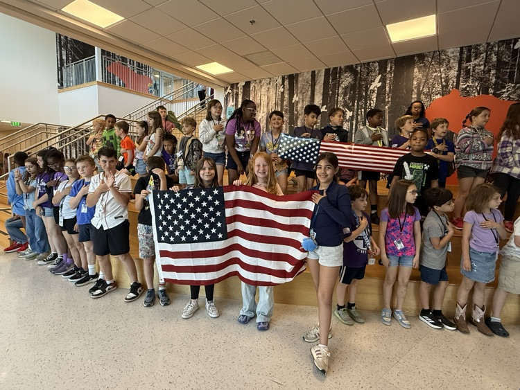 Kids gathered for the month of the Military Kid Parade. Students smiled while holding an American Flag.