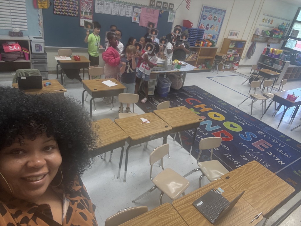 Mrs. Battle posing with students and their Mrs. Battle fans