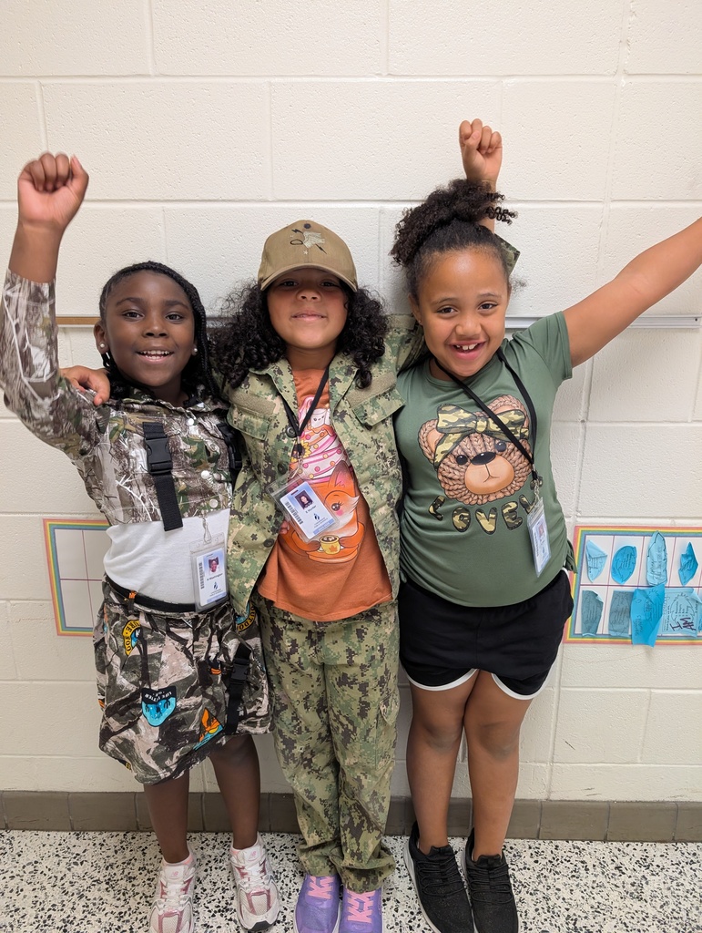 students wearing camo holding up their fists