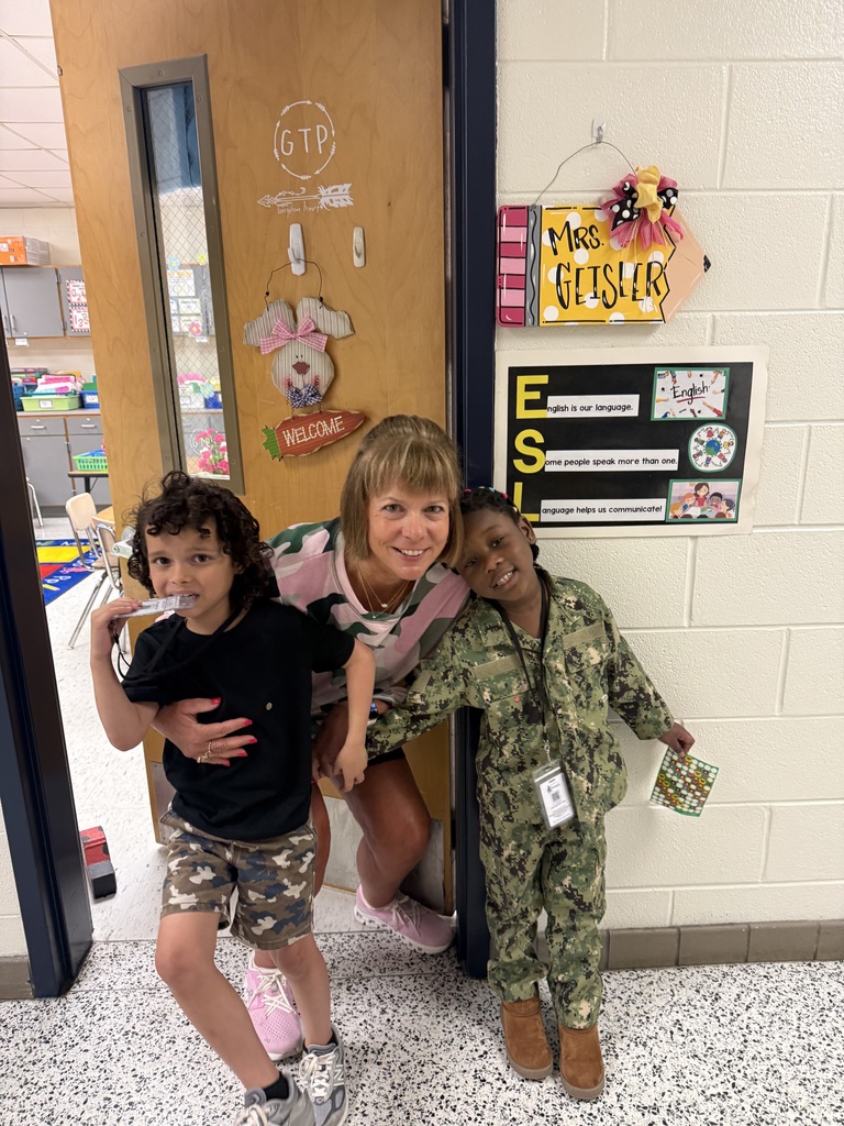 staff posing with students in camo gear
