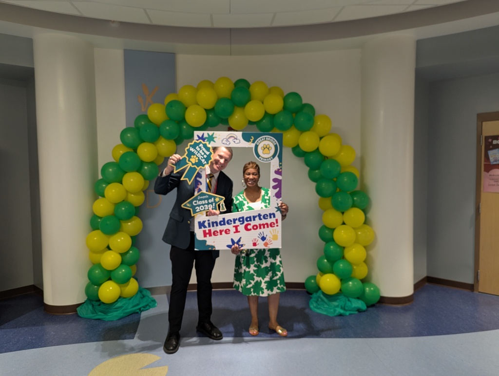 School administrators smiling and welcoming families at Kindergarten Kickoff, representing leadership support for incoming kindergarten students and their families.
