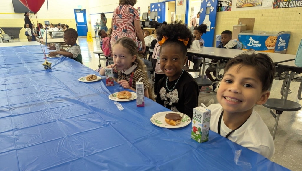 Students eating donut for treat for troops.