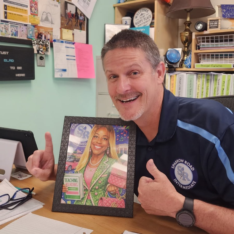 Mr. Triolet excitedly showing off a framed AI photo of Ms. Alexander. 