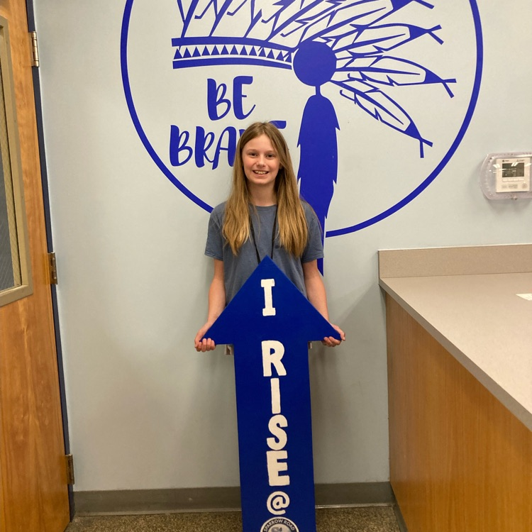 Zoe holding up the “I rise” arrow. 