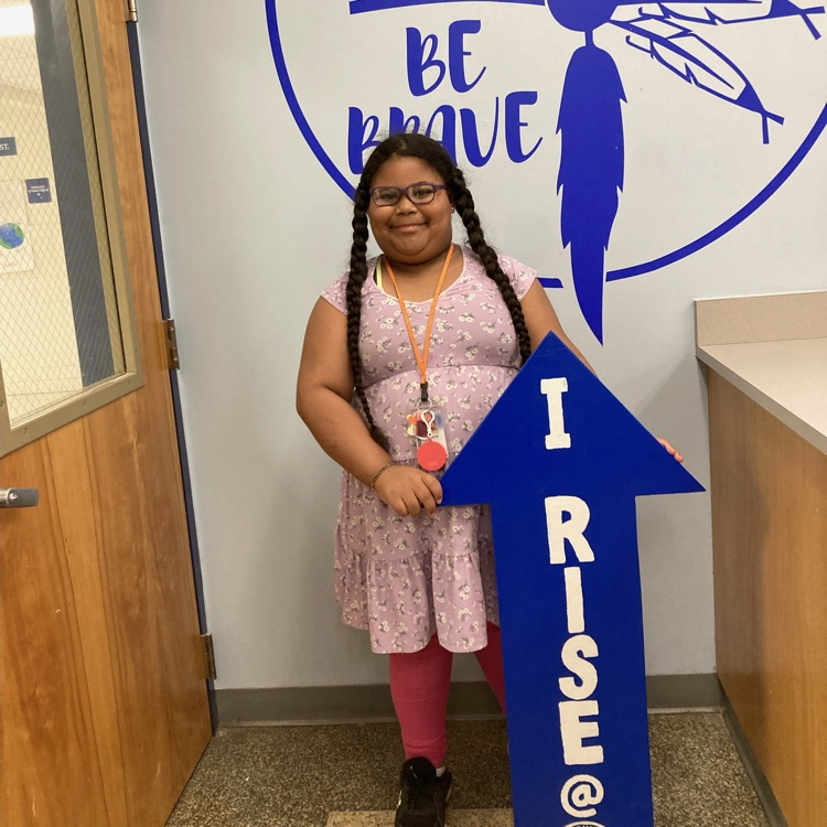 Camille holding up the “I rise” arrow. 