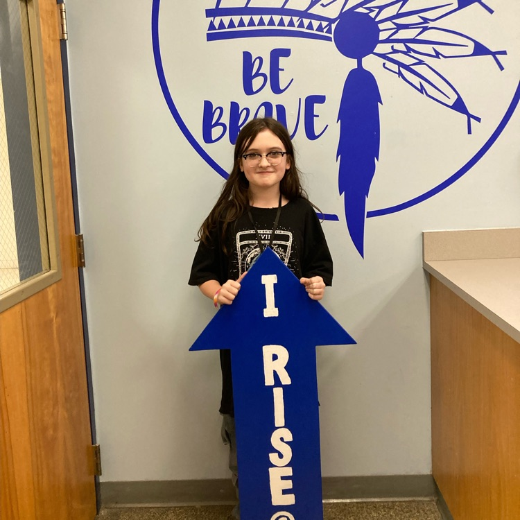 Eden holding up the “I rise” arrow. 