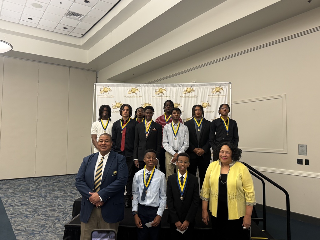 Group of middle school award recipients wearing medals pose on a stage with two adults at the New Chesapeake Men for Progress ceremony, standing in front of an event backdrop