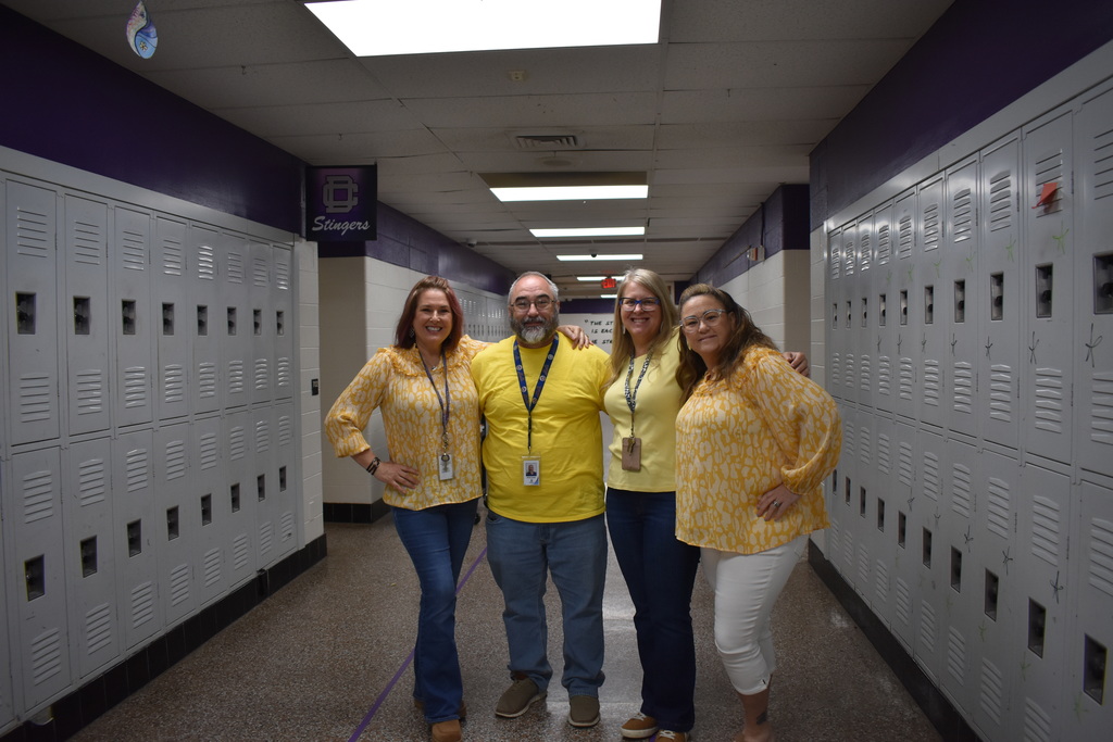 Four teachers wearing a yellow to celebrate the month of the military child