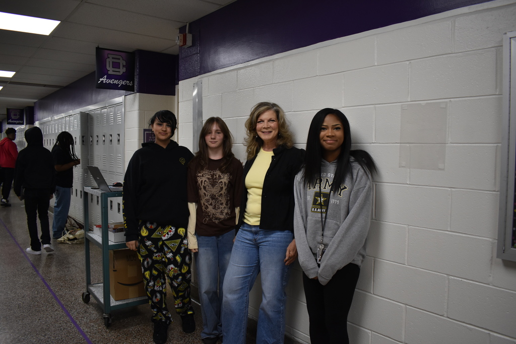 A teacher and three students wearing a yellow to celebrate the month of the military child