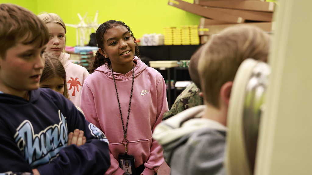 A student watches as her classmate takes a turn viewing a sample 
