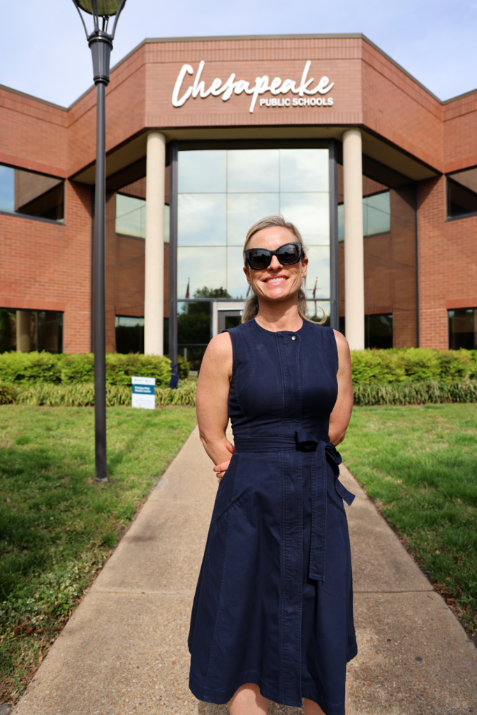 Dr. Tucker smiling proudly in front of the School Administration Building.