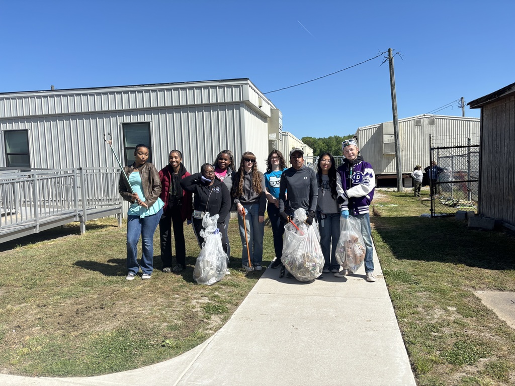 NHS and Environmental Club members holding trash bags from their clean up day in honor of Earth Day