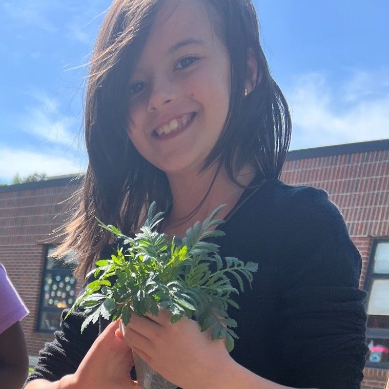 Earth Day: Student planting a marigold