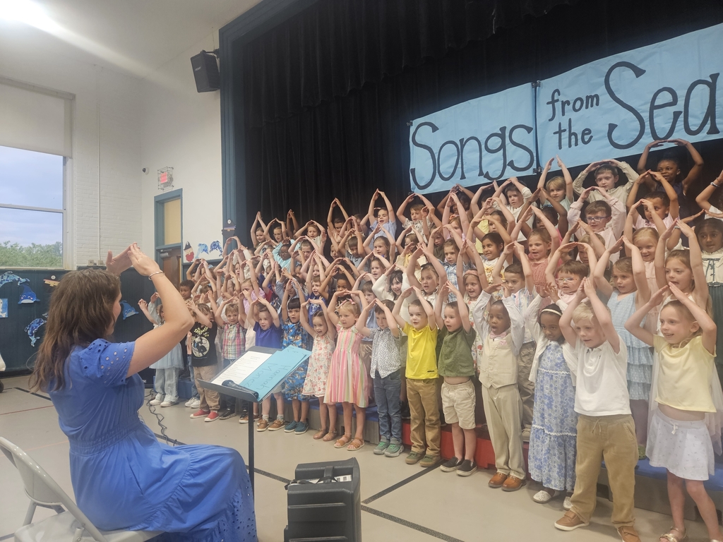 Kindergarten students performing hand motions and singing.