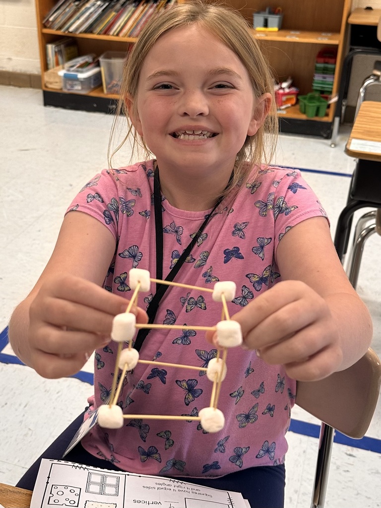A Little Brave student holding her handmade 3D  shape made of marshmallows and toothpicks.