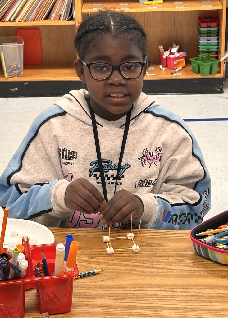 A Little Brave student holding her handmade 3D  shape made of marshmallows and toothpicks.