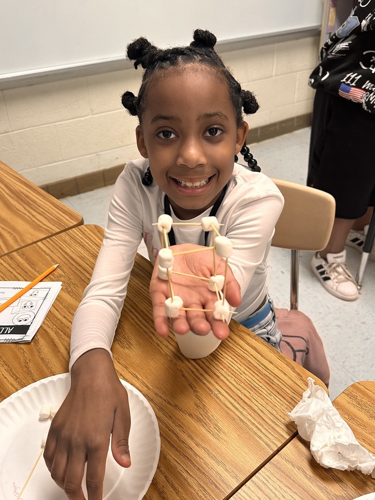 A Little Brave student holding her handmade 3D  shape made of marshmallows and toothpicks.