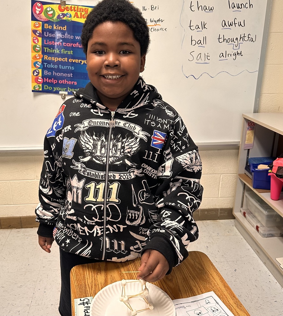 A Little Brave student holding his handmade 3D  shape made of marshmallows and toothpicks.