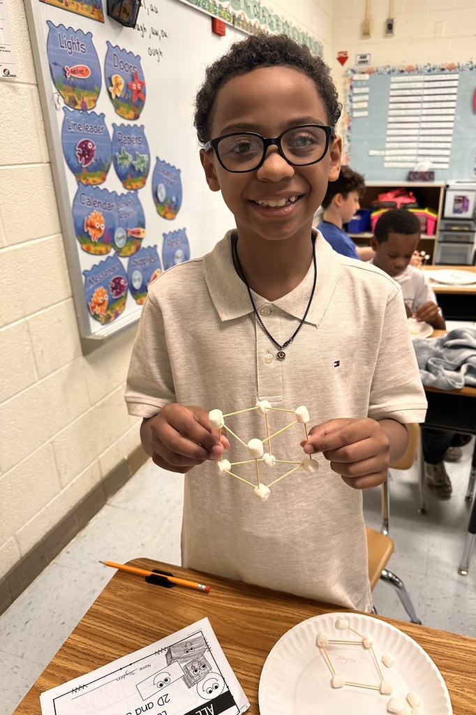 A Little Brave student holding his handmade 3D  shape made of marshmallows and toothpicks.