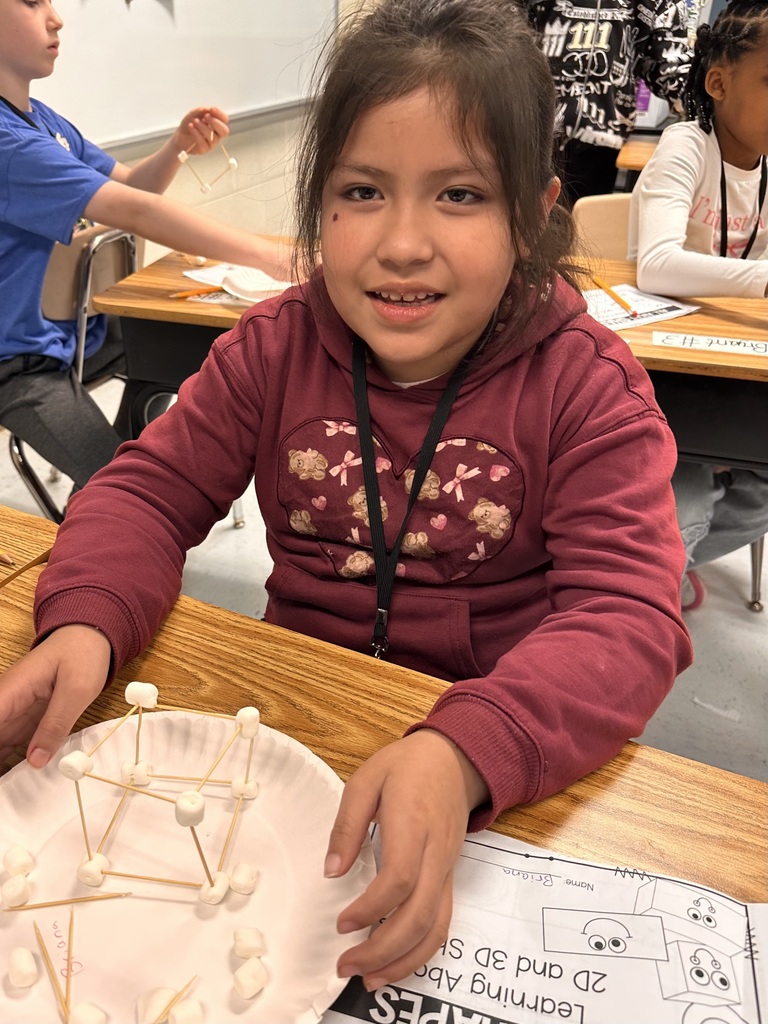 A Little Brave student holding her handmade 3D  shape made of marshmallows and toothpicks.