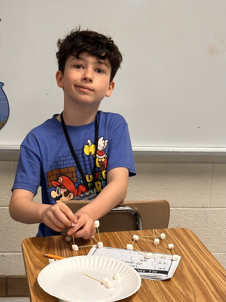 A Little Brave student holding his handmade 3D  shape made of marshmallows and toothpicks.