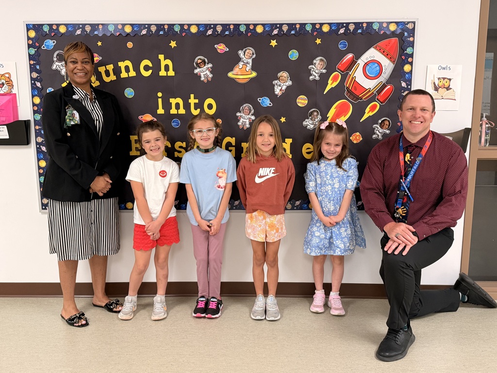 March Students of the Month pose with school administrators and smile for a group photo recognizing trustworthiness.