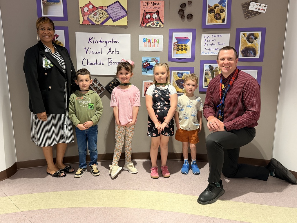March Students of the Month pose with school administrators and smile for a group photo recognizing trustworthiness.