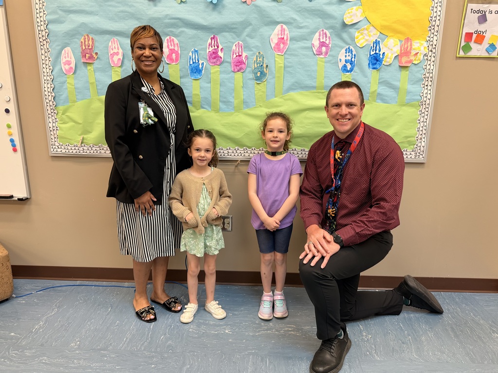 March Students of the Month pose with school administrators and smile for a group photo recognizing trustworthiness.