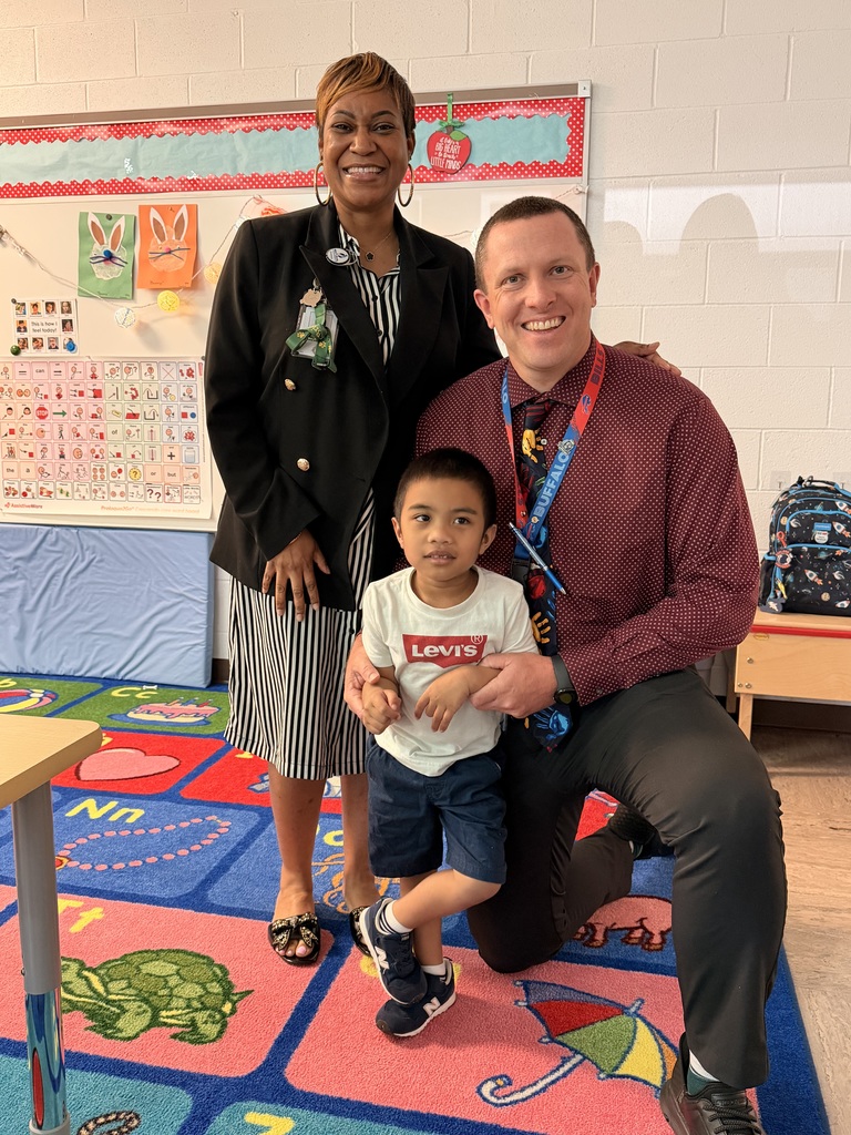 March Students of the Month pose with school administrators and smile for a group photo recognizing trustworthiness.