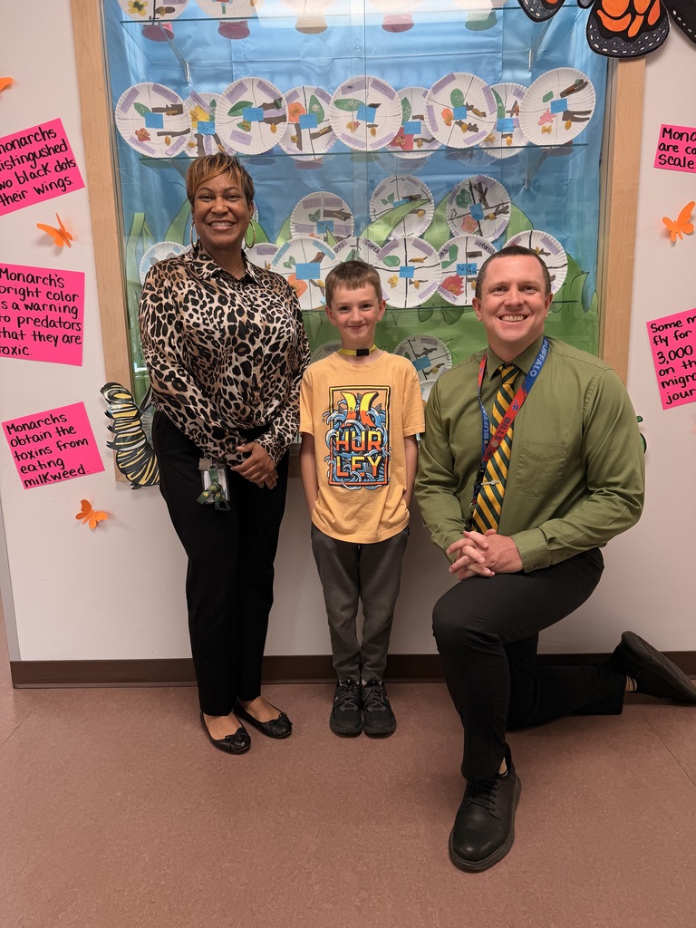 March Students of the Month pose with school administrators and smile for a group photo recognizing trustworthiness.