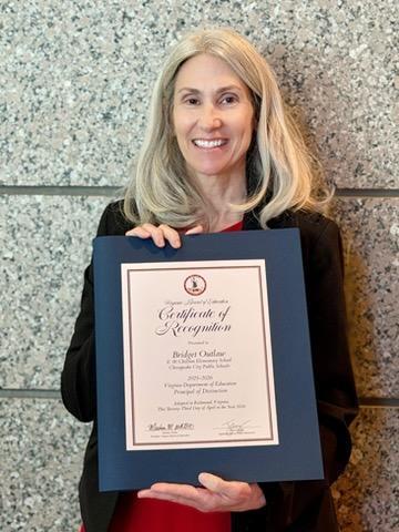 Bridget Outlaw celebrates with her award for Principal of Distinction