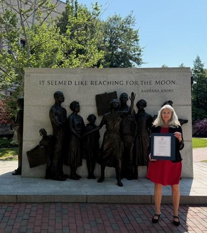 Bridget Outlaw celebrates with her award for Principal of Distinction