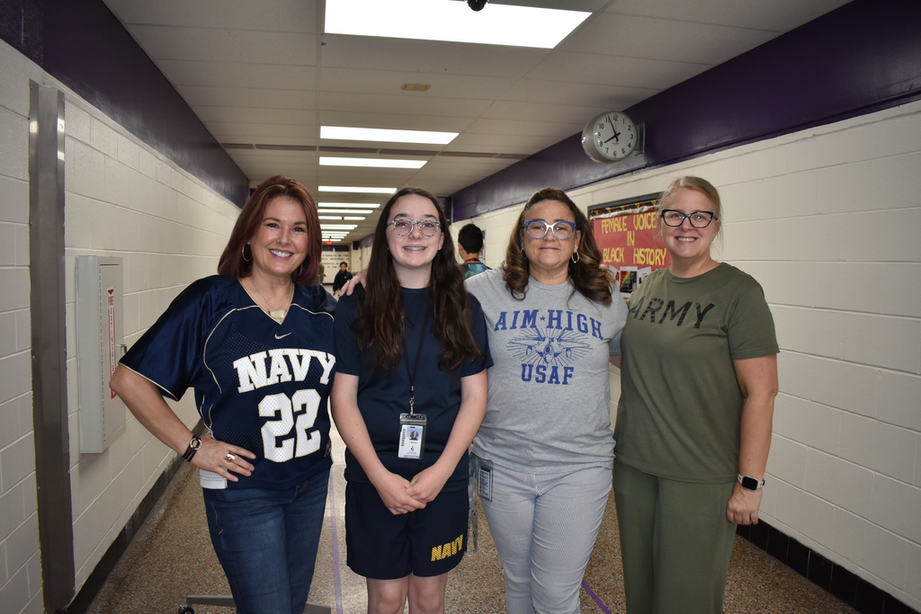 three teachers and a student wearing their military outfits