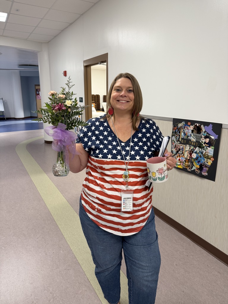 Teacher Mrs. Bigland posing and showing off the pretty floral arrangement she was given after her class visited the florists.