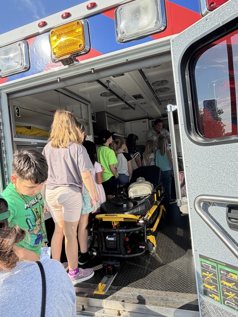 Students excitedly getting to walk through an ambulance on Career Day.