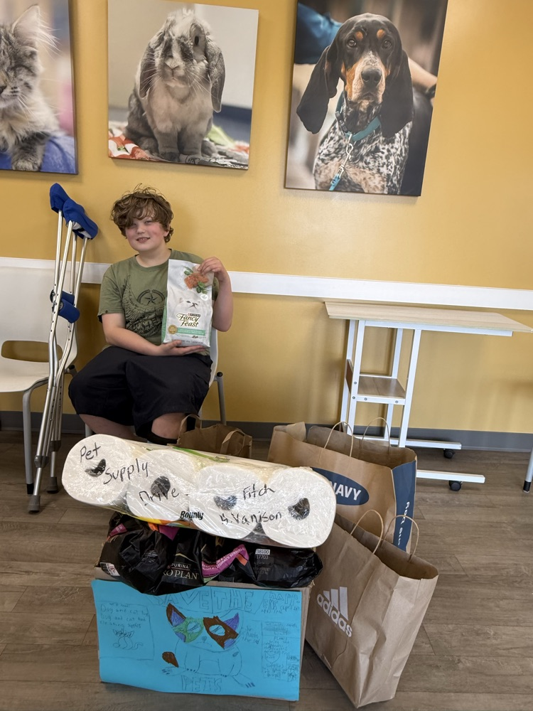 student holding supplies from pet and food drive